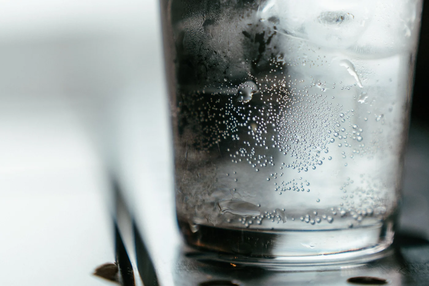 Fine bubbles in a glass of clear sparkling water.