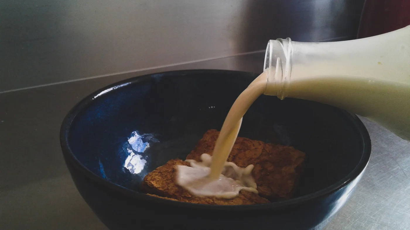 Milk being poured into a bowl
