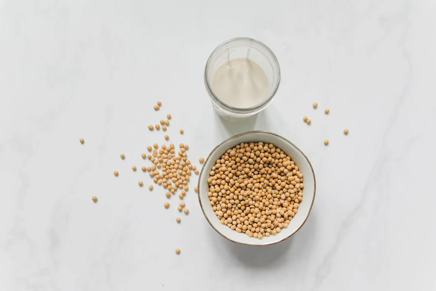 Soybeans beside a glass of soy milk
