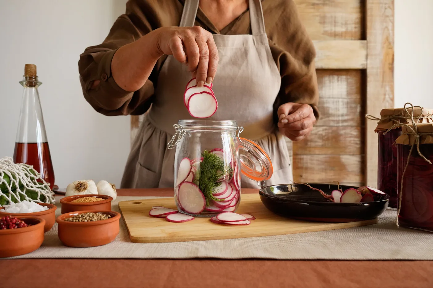 Hands preparing food in a glass jar
